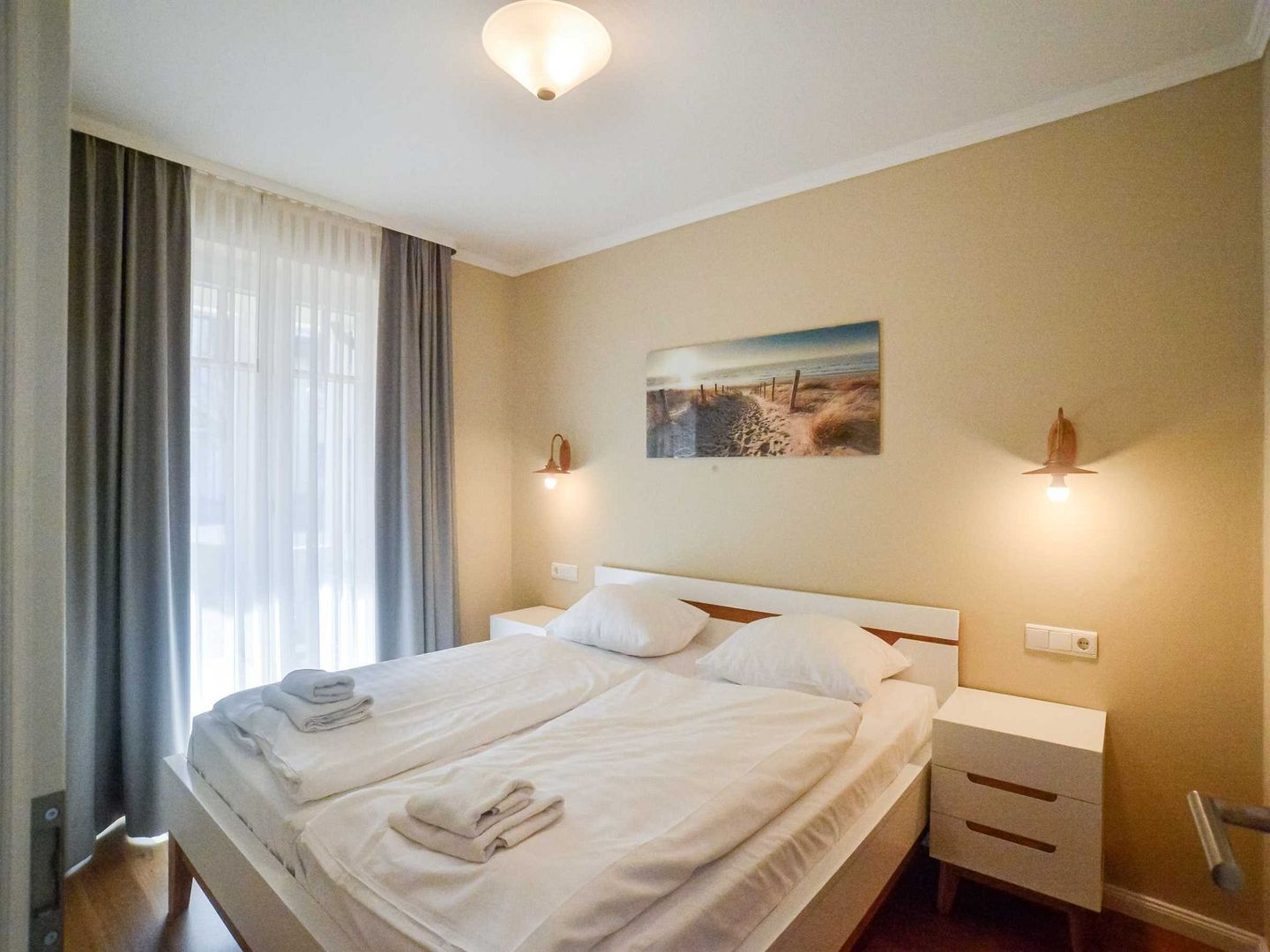 Schlafzimmer mit Doppelbett und Strandbild