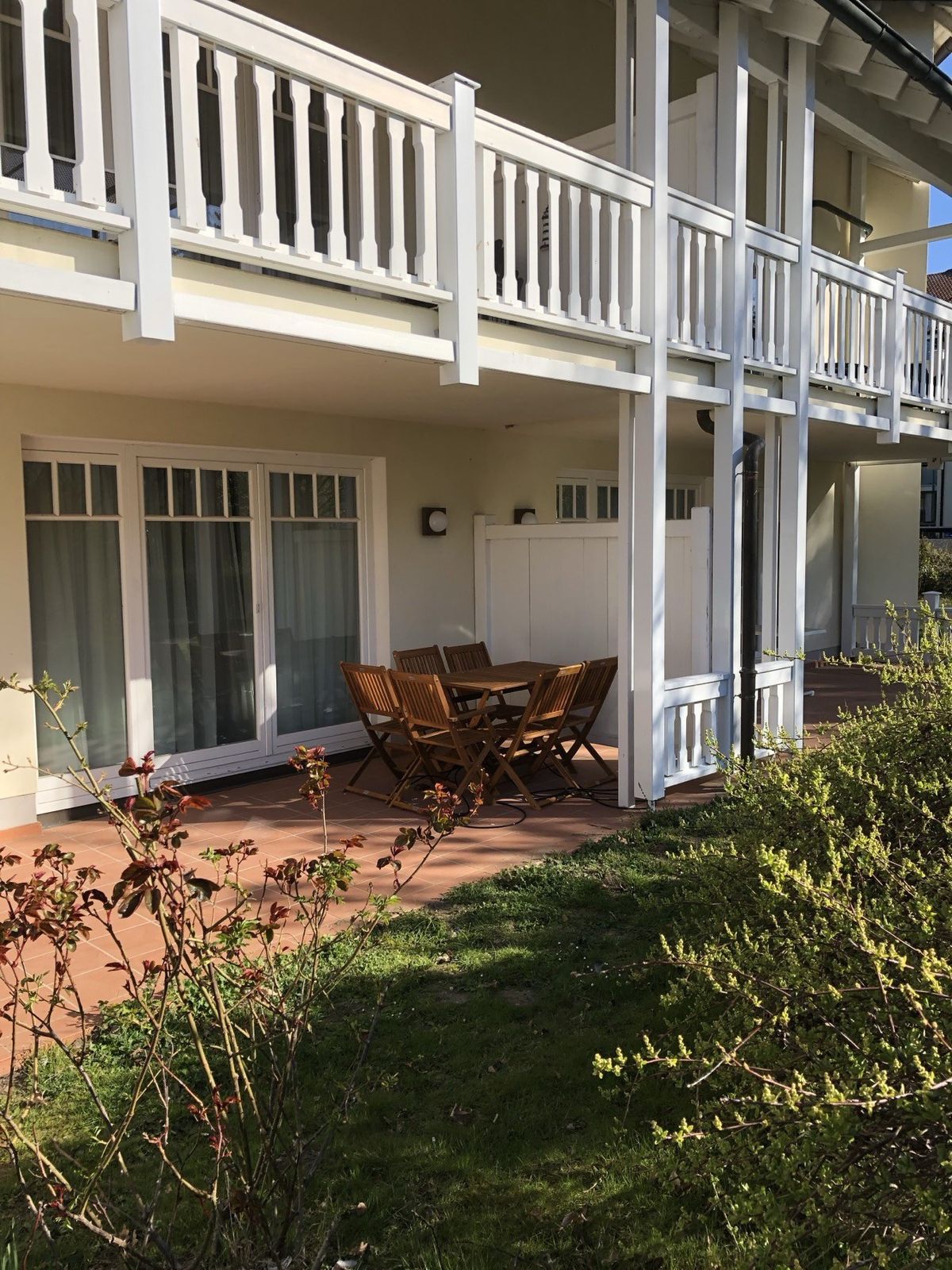Ebenerdige Terrasse mit Tisch und Stühlen am Garten